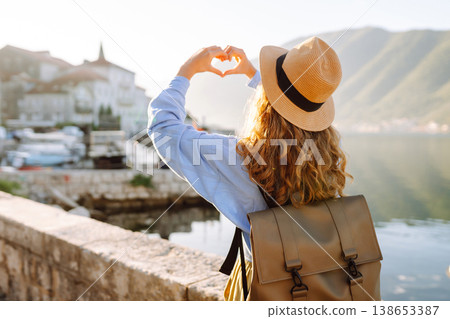 Woman tourist holding hands in shape of heart looking at panoramic landscape of city. Lifestyle. Woman tourist holding hands in shape of heart looking at panoramic landscape of city. Lifestyle. 138653387