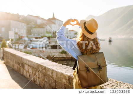 Woman tourist holding hands in shape of heart looking at panoramic landscape of city. Lifestyle. Woman tourist holding hands in shape of heart looking at panoramic landscape of city. Lifestyle. 138653388