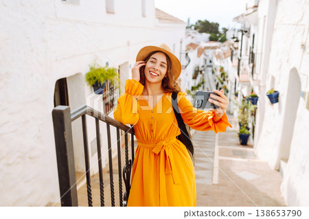 Young woman to take a quick selfie as a souvenir of her trip in a sunny village. Tourist Adventure Young woman to take a quick selfie as a souvenir of her trip in a sunny village. Tourist Adventure 138653790