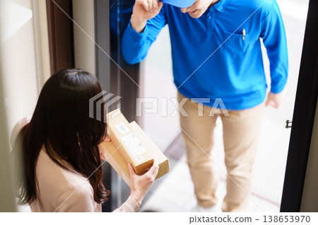 一名來自Kumo Commercial公司的男子正在遞送一個小包裹。 138653970
