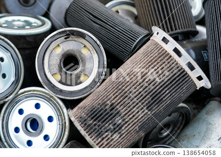 Pile of used dirty oil filters close up automotive waste recycling and car maintenance service parts 138654058