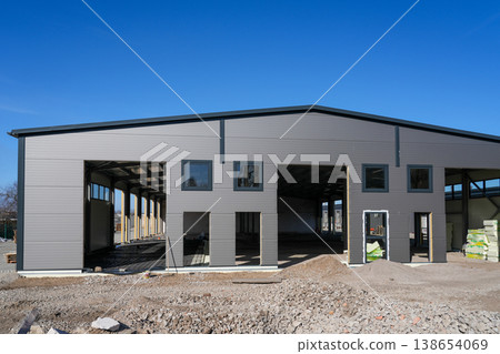 Industrial building with sandwich panel facade under construction and open warehouse structure Industrial building with sandwich panel facade under construction and open warehouse structure 138654069