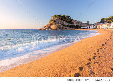 Beach and fortified old town at sunrise in Tossa de Mar, Spain 138654745