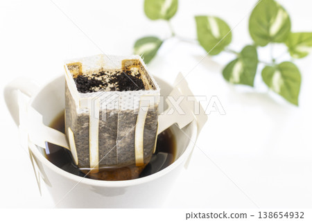 用滴漏咖啡袋沖泡好的咖啡盛裝在一個咖啡杯中。 用滴漏咖啡袋沖泡好的咖啡盛裝在一個咖啡杯中。 138654932