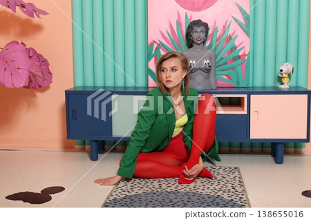 Woman with green blazer and red pants in retro studio environment 138655016