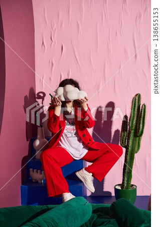 Masked playful portrait woman covering face with plush 138655153