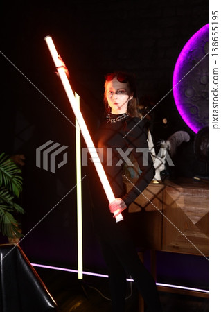 Modern female figure with glowing staff and cinematic effects Modern female figure with glowing staff and cinematic effects 138655195
