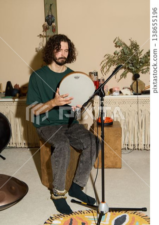 Artisan carefully examines and tunes handcrafted frame drum 138655196