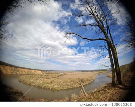 The Don River flows in a curved path across the land. Trees stand nearby as vast clouds fill the sky. This scene shows nature on a clear day. The Don River flows in a curved path across the land. Trees stand nearby as vast clouds fill the sky. This scene shows nature on a clear day. 138655368