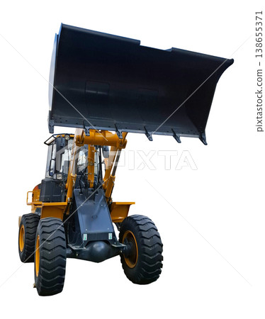 A yellow industrial wheel loader stands at a low angle with its black bucket raised. This machine is designed for heavy lifting and construction tasks in various locations. 138655371