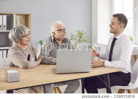 Smiling elderly couple talking with man advisor about health insurance or investments in office. 138655859