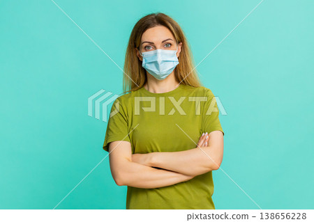 Woman putting on medical mask for self-care protection against cold flu preventive health measure 138656228