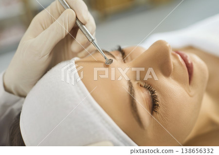 Faceless woman cosmetologist removing pores, pimples or blackheads on face  138656332
