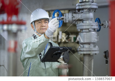 Image of a senior worker inspecting building equipment; building maintenance staff. 138657007