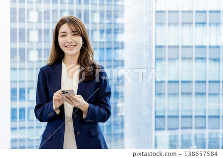 A mixed-race woman using a smartphone A mixed-race woman using a smartphone 138657584