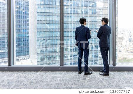 Silhouettes of a business team standing by a window Silhouettes of a business team standing by a window 138657757