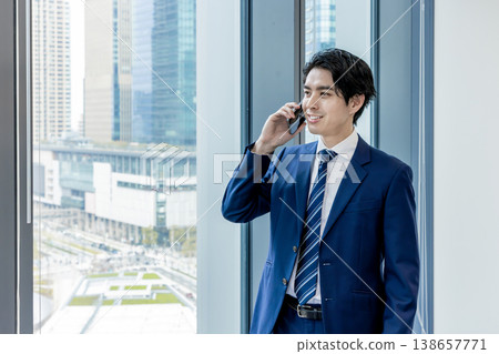 商務人士在辦公室使用智慧型手機，背景是一棟漂亮的建築。 138657771