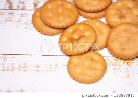 Round crackers against a white wood grain background Round crackers against a white wood grain background 138657915