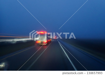 Blurred motion of a truck on a blue foggy evening highway Blurred motion of a truck on a blue foggy evening highway 138657993