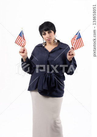 Patriotic woman holding two American flags in studio Patriotic woman holding two American flags in studio 138658051