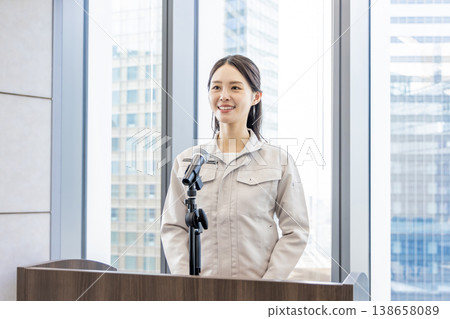 A woman in work clothes giving an explanation. A woman in work clothes giving an explanation. 138658089