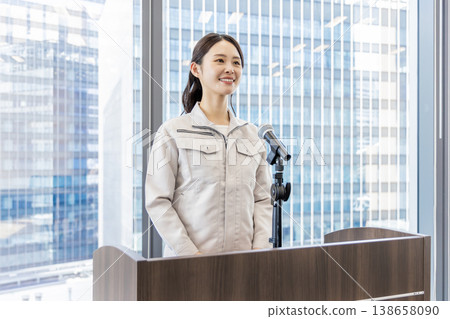 A woman in work clothes giving an explanation. A woman in work clothes giving an explanation. 138658090