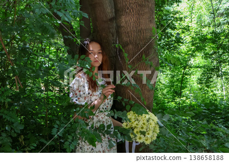 Woman holding a bouquet of flowers in the woods Woman holding a bouquet of flowers in the woods 138658188