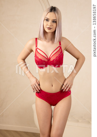 Young woman in red lace lingerie posing in studio Young woman in red lace lingerie posing in studio 138658197