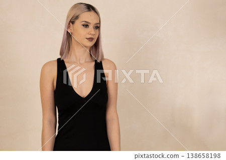 Confident woman in black nightgown posing against wall Confident woman in black nightgown posing against wall 138658198