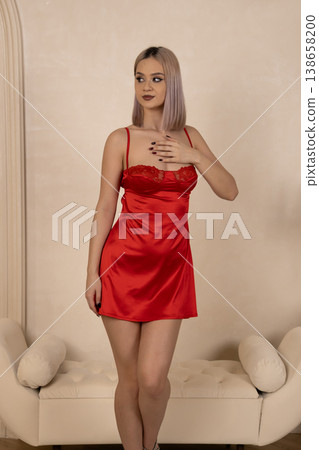 Confident woman in red nightgown posing for camera Confident woman in red nightgown posing for camera 138658200