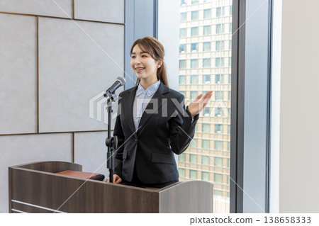 A white woman speaking into a microphone at a workshop. A white woman speaking into a microphone at a workshop. 138658333