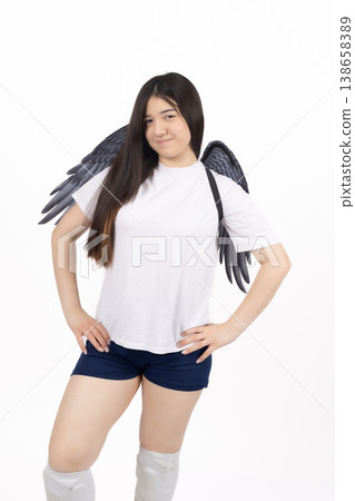 Beautiful woman with angel wings looking away in studio Beautiful woman with angel wings looking away in studio 138658389
