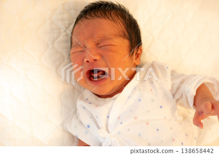 A crying baby lying down 138658442