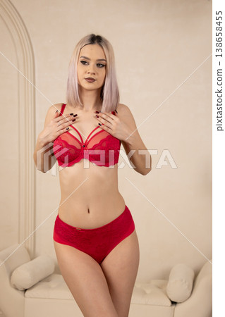Young woman in red lace bra posing in studio Young woman in red lace bra posing in studio 138658455