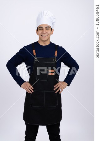 Male cook in black apron standing with hands in pockets 138658461