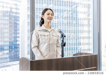 A woman in work clothes giving an explanation. A woman in work clothes giving an explanation. 138658516