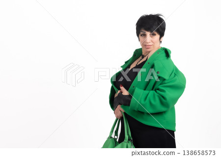 Woman in green coat holding a black shopping bag Woman in green coat holding a black shopping bag 138658573
