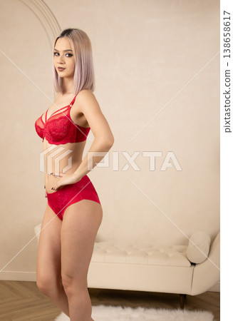 Stunning woman in red lace lingerie posing against wall Stunning woman in red lace lingerie posing against wall 138658617