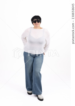 Plus size woman standing in casual white clothes and posing Plus size woman standing in casual white clothes and posing 138658645