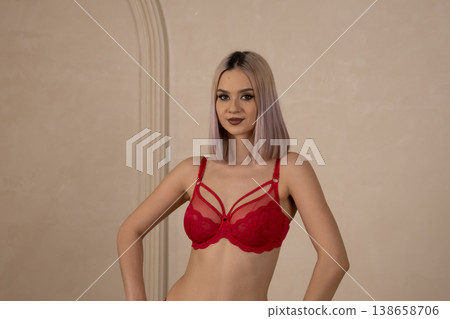 Young woman in red lace lingerie posing sideways Young woman in red lace lingerie posing sideways 138658706