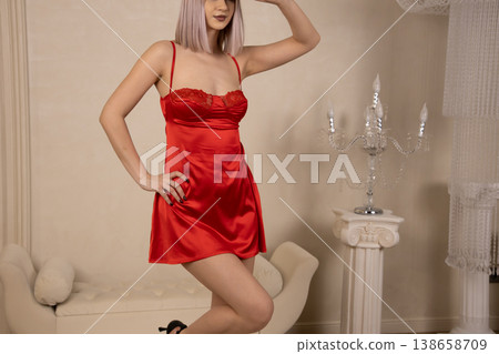 Confident woman in red nightgown posing with hand on hip Confident woman in red nightgown posing with hand on hip 138658709