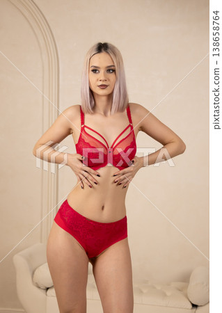 Beautiful woman in red lingerie posing for camera in studio Beautiful woman in red lingerie posing for camera in studio 138658764