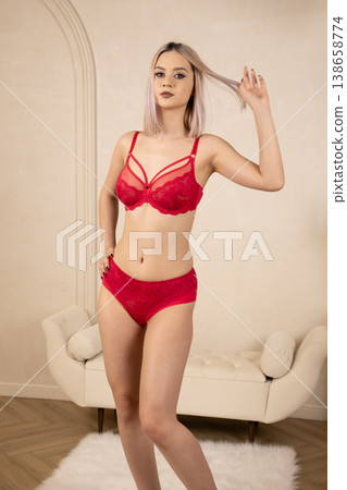 Stunning woman in red lingerie posing against white wall Stunning woman in red lingerie posing against white wall 138658774