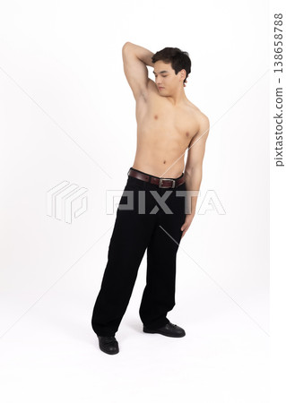 Athletic man posing with arms raised in studio 138658788
