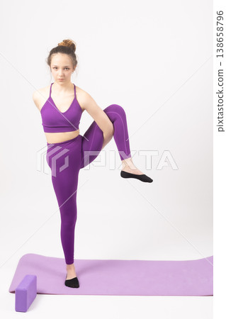 Young woman in purple sportswear practicing yoga balance Young woman in purple sportswear practicing yoga balance 138658796