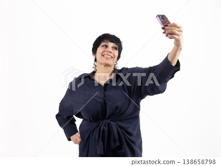 Woman in dark shirt taking a selfie with a smartphone Woman in dark shirt taking a selfie with a smartphone 138658798