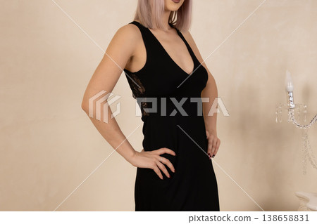 Confident woman in black silk nightgown posing in studio Confident woman in black silk nightgown posing in studio 138658831