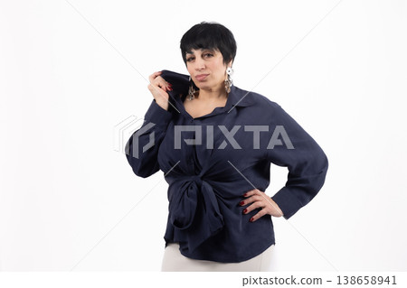 Woman in dark shirt holding a smartphone and looking at it Woman in dark shirt holding a smartphone and looking at it 138658941