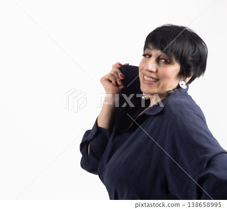 Woman touching her short dark hair and smiling gently Woman touching her short dark hair and smiling gently 138658995