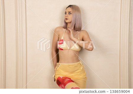 Young woman in yellow bikini posing with hands on head 138659004